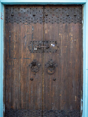 Fototapeta premium Old wooden door with locks and rings. Closed door.