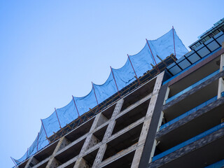 Construction nets on an unfinished building. Construction industry. Cement and concrete.