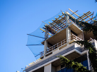 Construction nets on an unfinished building. Construction industry. Cement and concrete.