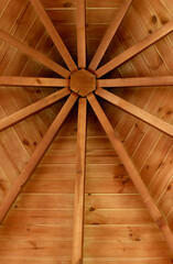 A web like pattern of wooden planks supporting a pyramidal roof vertical stock image
