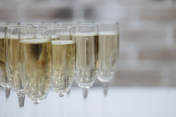 Champagne wine into wine glasses. Champagne flutes on a wedding reception or on celebration party 