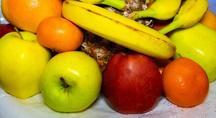Fresh fruits displayed in a decorative bowl at a sunny kitchen table