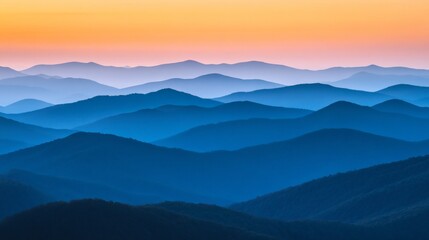 Fototapeta premium Serene Layers of Blue Mountains Under Vibrant Sunset Sky