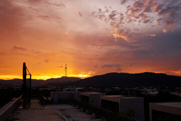 Scenic Sunset Over Cityscape with Vibrant Colors and Silhouetted Mountains