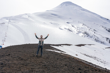 A smiling explorer in the snowy mountains of the osorno volcano, a spirit of freedom and tranquility.