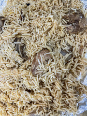 Festive pilaf Kacchi Mutton Biryani with nuts, raisins, fried onion closeup on the plate