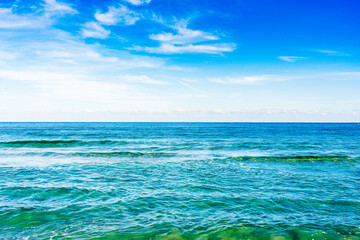 ocean with clouds in blue sky
