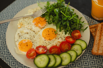Delicious and nutritious scrambled eggs with arugula and cherry tomatoes on a plate, served with crispy toast on a wooden table. The perfect breakfast to start your day energized.