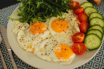 Delicious and nutritious scrambled eggs with arugula and cherry tomatoes on a plate, served with crispy toast on a wooden table. The perfect breakfast to start your day energized.