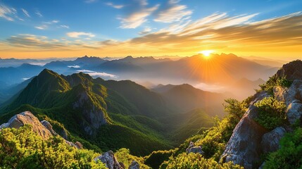 Majestic mountain range at sunrise with golden light and misty valleys