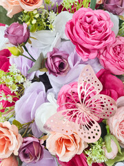 Background of beautiful colorful flower bouquet with butterfly decoration. Handcrafted flower bouquet and a pink butterfly to decorate. Concept of holiday, special day, welcoming spring or summer.