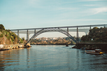The Dona Maria Pia Bridge spans the Douro River in Porto, Portugal, showcasing an elegant iron arch design, historic engineering, and scenic views of the surrounding area