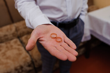 Elegant Wedding Rings Held in a Man's Hand Symbolizing Love and Commitment