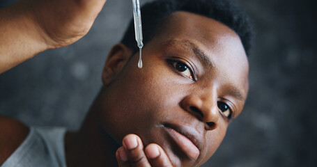 Serum, skincare and facial with black man with dropper for beauty, spa treatment and vitamin c. Dermatology, collagen and cosmetics with person on dark background for glow, self care and oil pov