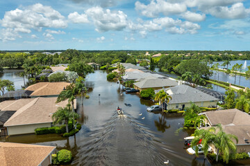 Fototapeta premium Hurricane Debby flooded street in Sarasota, Florida. Victims boating on rainfall flood waters between rural homes in residential area