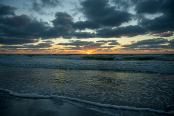 Obraz premium Ocean sunset landscape with soft evening sea water waves crushing on sandy beach