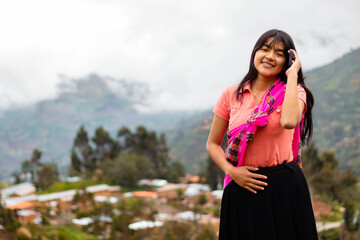 Mujer campesina atractiva en América Latina, feliz mientras usa un teléfono inteligente mirada a...