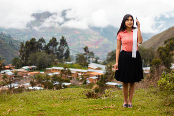 Mujer campesina atractiva en América Latina, feliz mientras usa un teléfono inteligente mirada a...