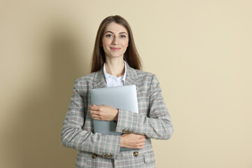 Portrait of smiling banker with laptop on beige background