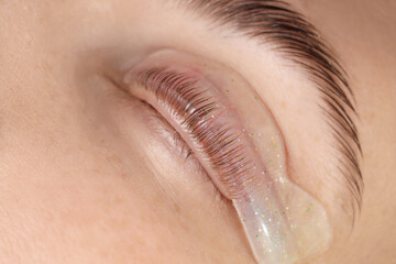 Woman undergoing procedure of eyelash lamination, closeup
