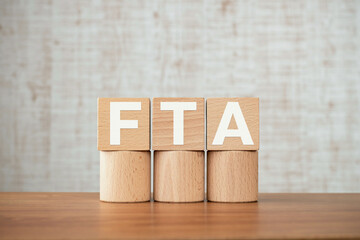 There is wood cube with the word FTA. It is an abbreviation for Free Trade Agreement as...