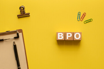 There is wood cube with the word BPO. It is an abbreviation for Business Process Outsourcing as...
