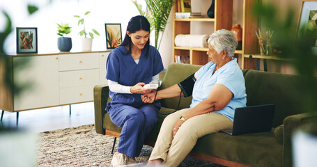 Senior woman, nurse and blood pressure test on sofa for cardiovascular health, heart rate and checkup. Professional, elderly patient and machine in home to monitor hypertension and medical support © peopleimages.com