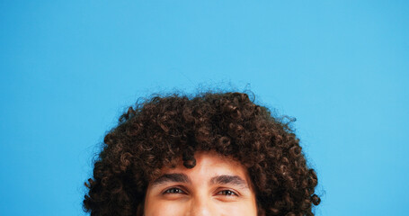 Man, head and portrait with space in studio for curly hair, style or volume isolated on a blue...