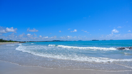 Natural Beach Scenery With White Waves And Blue Water, Breaking On The Shore Of Clean White Sand