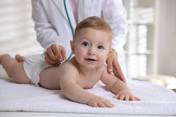 Pediatrician examining little child with stethoscope in clinic, closeup. Checking baby's health