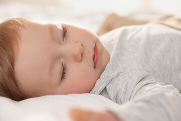 Cute little baby sleeping on bed at home, closeup