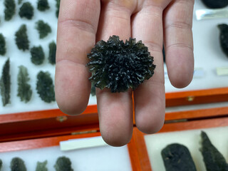 Hand holding a top Besednice Jezkovna moldavite