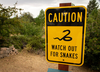 Sign warning to watch for snakes in a wilderness area