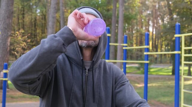 Man takes break after training on outdoor gym