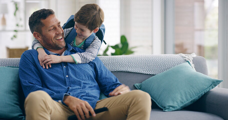 Obraz premium Boy, dad and hug on sofa with surprise, smile and watching tv with funny memory, care or play in home. Child, father and embrace on couch for television, streaming or movies with game in family house
