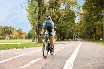 Group of athletic people riding bicycles outdoors