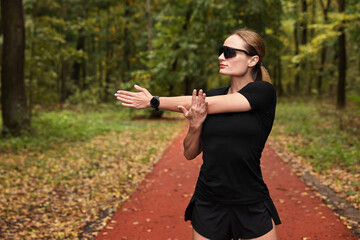 Young athletic woman stretching in park. Healthy lifestyle
