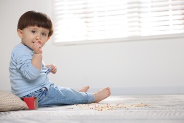 Fototapeta premium Little boy playing with matches at home, space for text. Child in danger