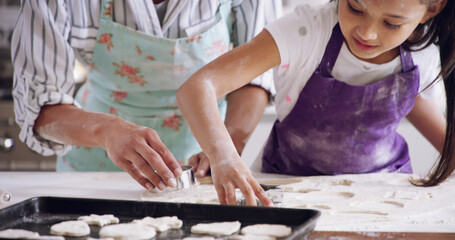 Mom, daughter and cookie cutter in home, baking together and pastry education for development. Mother, girl and helping parent press shape in dough, kitchen learning and support with dessert biscuits