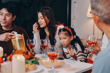 Merry Christmas! Happy family are having dinner at home. Celebration holiday and togetherness near tree.