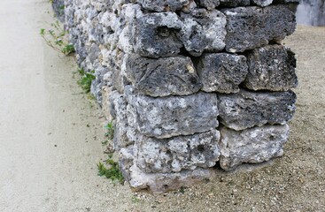 Volcanic stone and dead coral wall on a sandy path