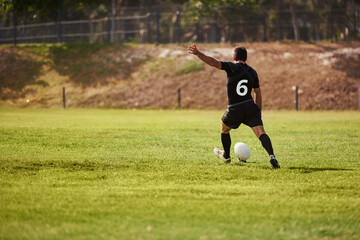 Ball, kicking and rugby with man on field from back for start of competition, game or tournament. Exercise, fitness and kickoff with sports player outdoor at venue for scoring or shooting at goal
