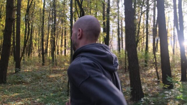 Athlete running on path, motion blur. Close-up on legs and shoes. Autumn leaves. Sport and healthy lifestyle concept