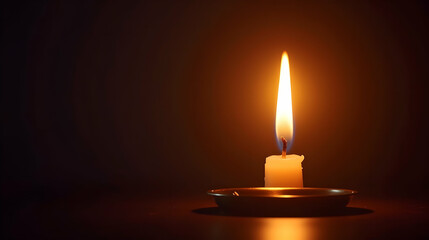 A single candle burns brightly, casting a warm glow against the dark background.  Its flame dances, a beacon of hope in the night.