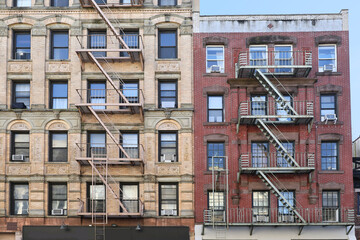 New York City, old apartment building with external fire ladder and ornamental carvings around windows