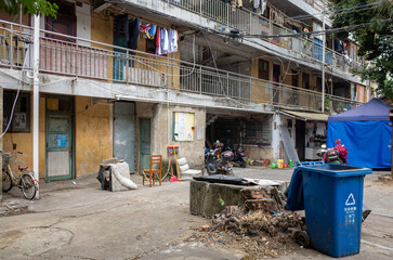a lower-income neighborhood in China with decaying and weathered residential apartment buildings, a...