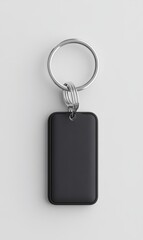 Fototapeta premium Minimalist Black Keychain with Rectangular Tag on White Background for Modern Lifestyle Decoration