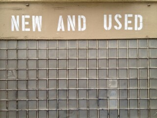 "New and Used" Vintage Store Sign on Glass Block Wall