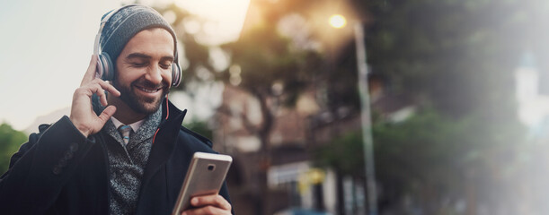 Headphones, music and smile with man in city for streaming, online audio and podcast. Happiness, connection and phone with person in urban town with mobile app for banner, playlist and subscribe