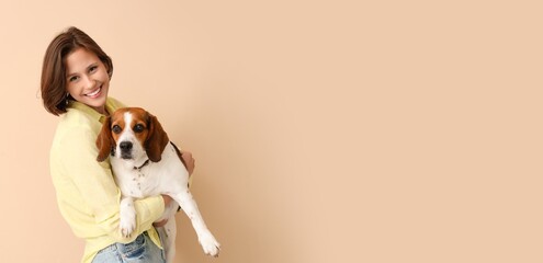 Young woman holding Beagle dog on beige background with space for text